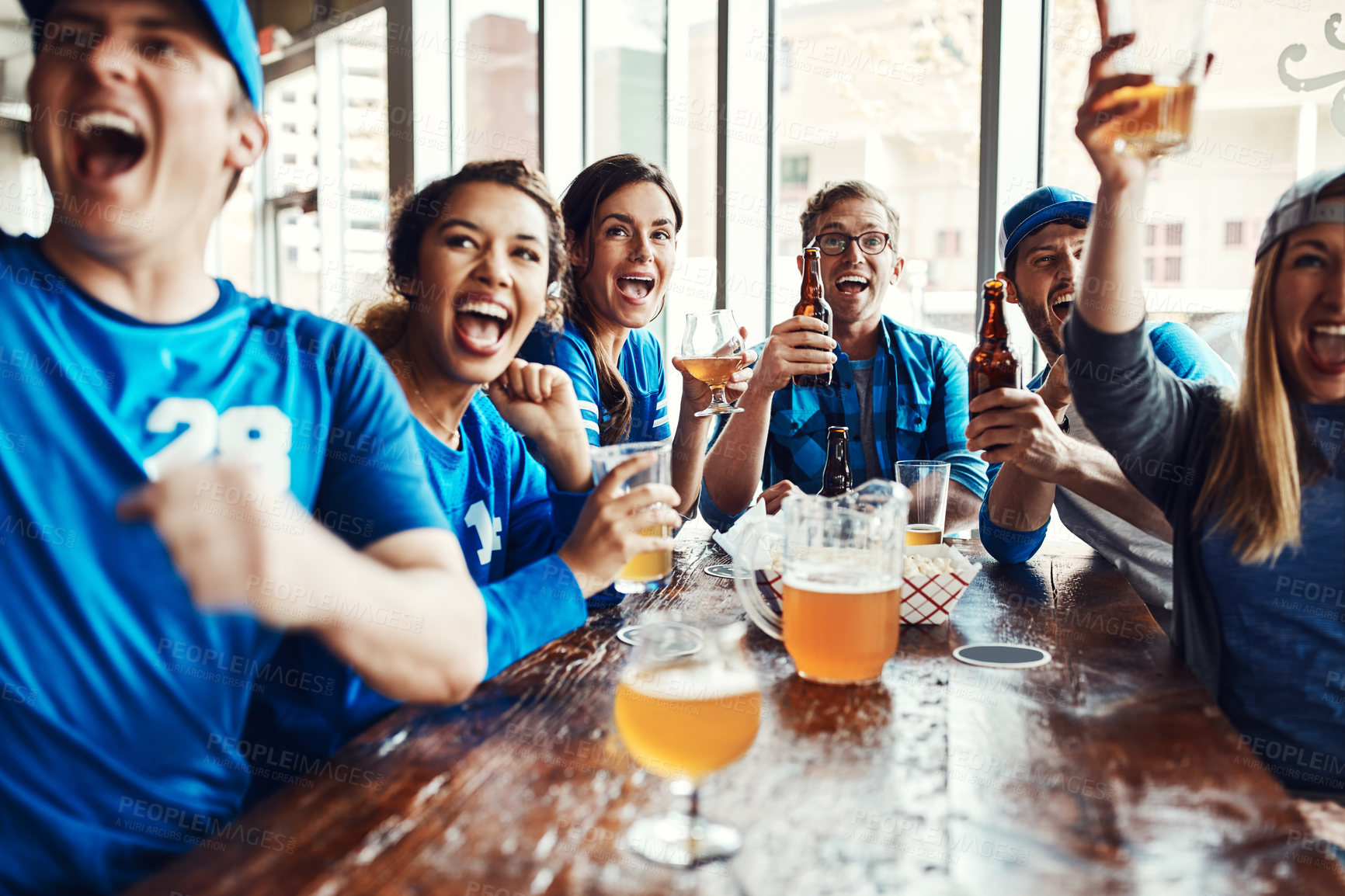 Buy stock photo Shot of people watching their favorite team live in a sports bar