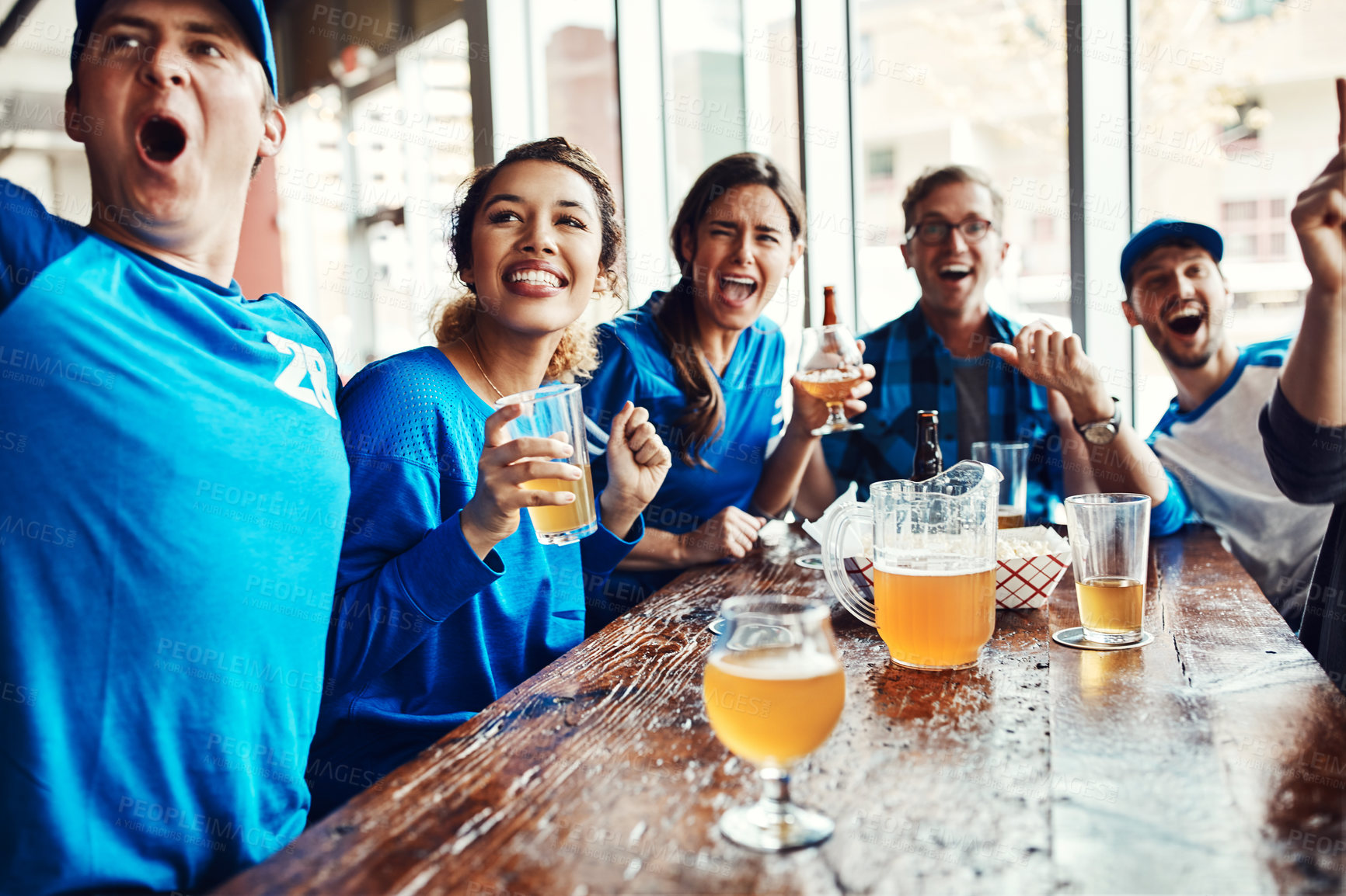 Buy stock photo Shot of people watching their favorite team live in a sports bar