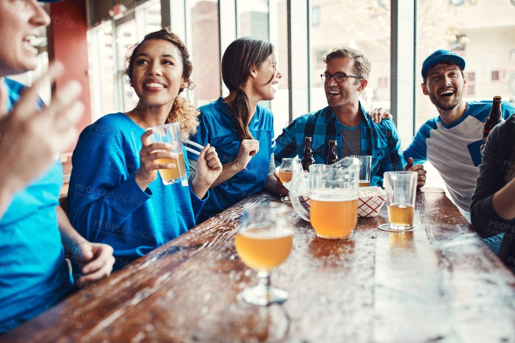 Buy stock photo Shot of people watching their favorite team live in a sports bar