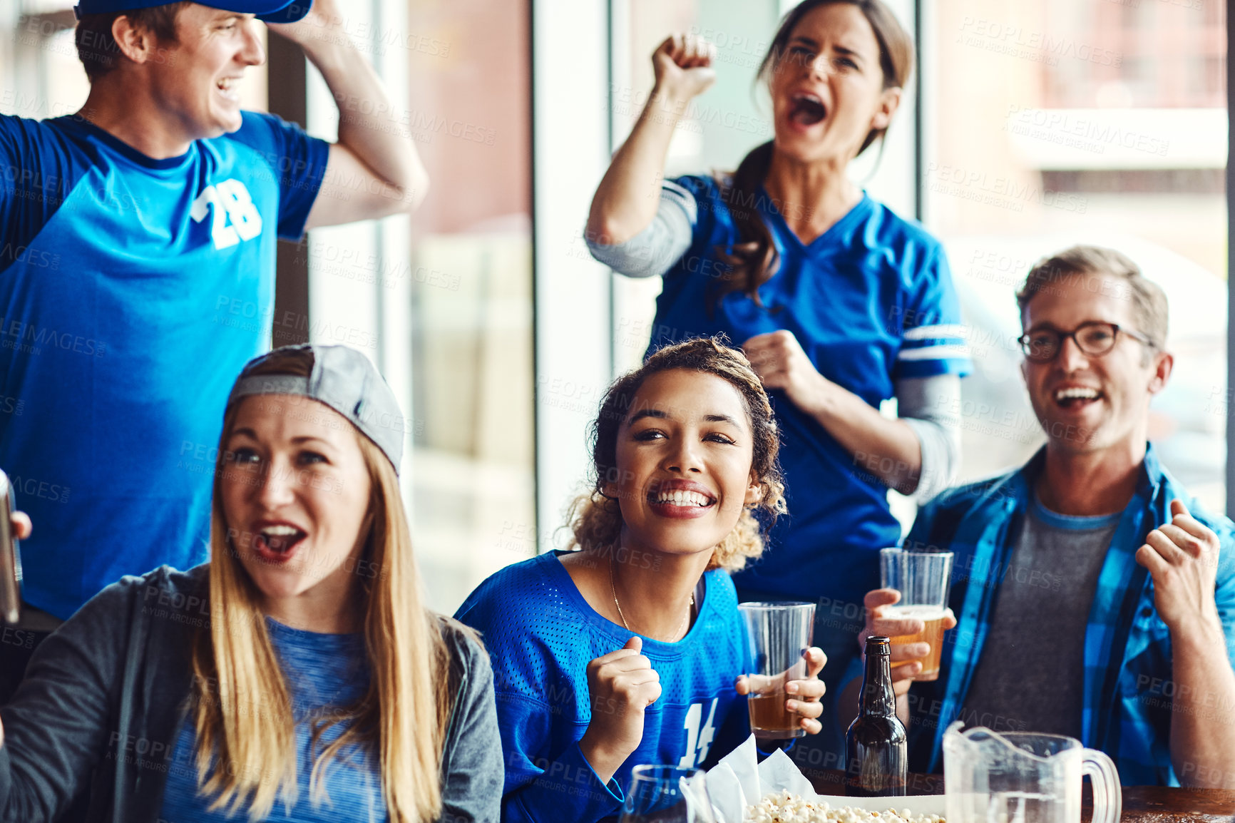 Buy stock photo Sports, fans and success with drinks for celebration, support and people watching tv team game in restaurant. Friends, cheering and live broadcast with happiness, excited and alcohol for baseball win