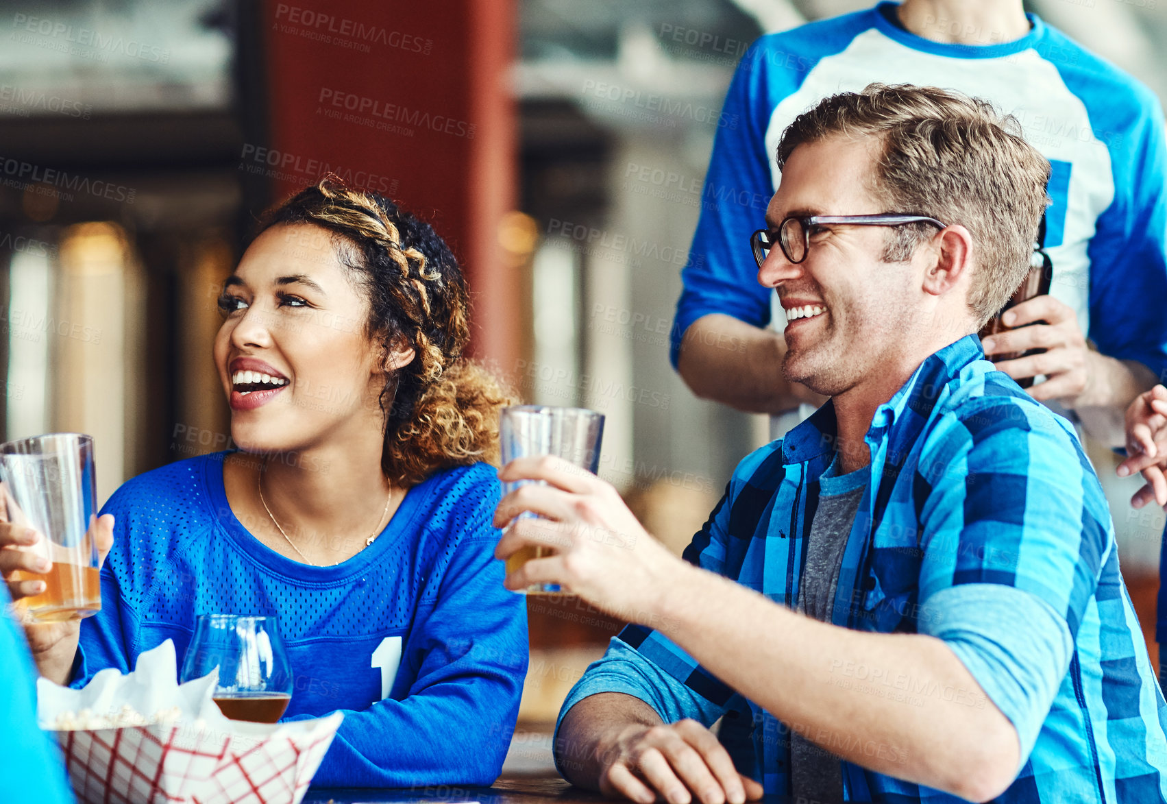 Buy stock photo Shot of a group of friends having beers while watching a sports game at a bar