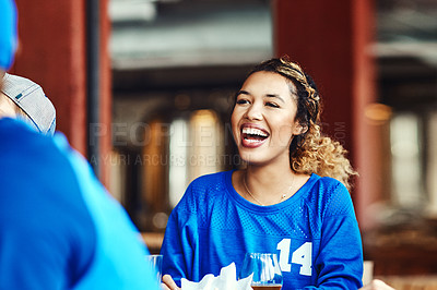 Buy stock photo Shot of a woman watching a sports game with friends at a bar