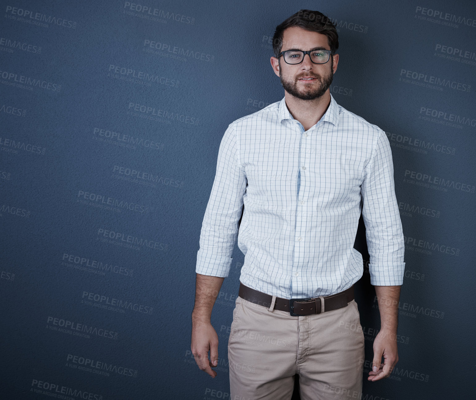 Buy stock photo Studio portrait of a handsome young businessman standing against a dark background