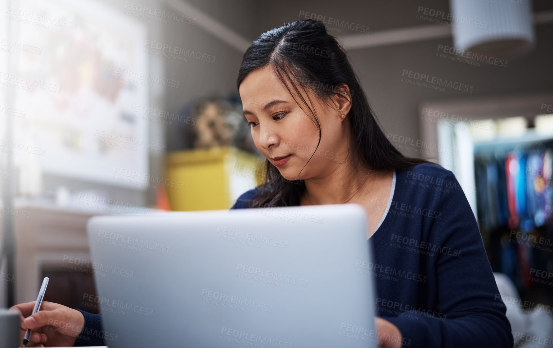 Buy stock photo Cropped shot of an attractive young female entrepreneur working on her laptop at home