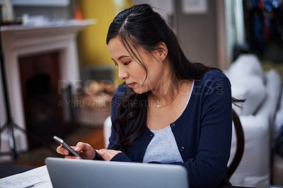 Buy stock photo Cropped shot of an attractive young female entrepreneur sending a text while working from home