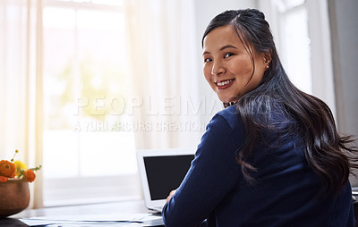Buy stock photo Rearview portrait of an attractive young female entrepreneur working on her laptop at home