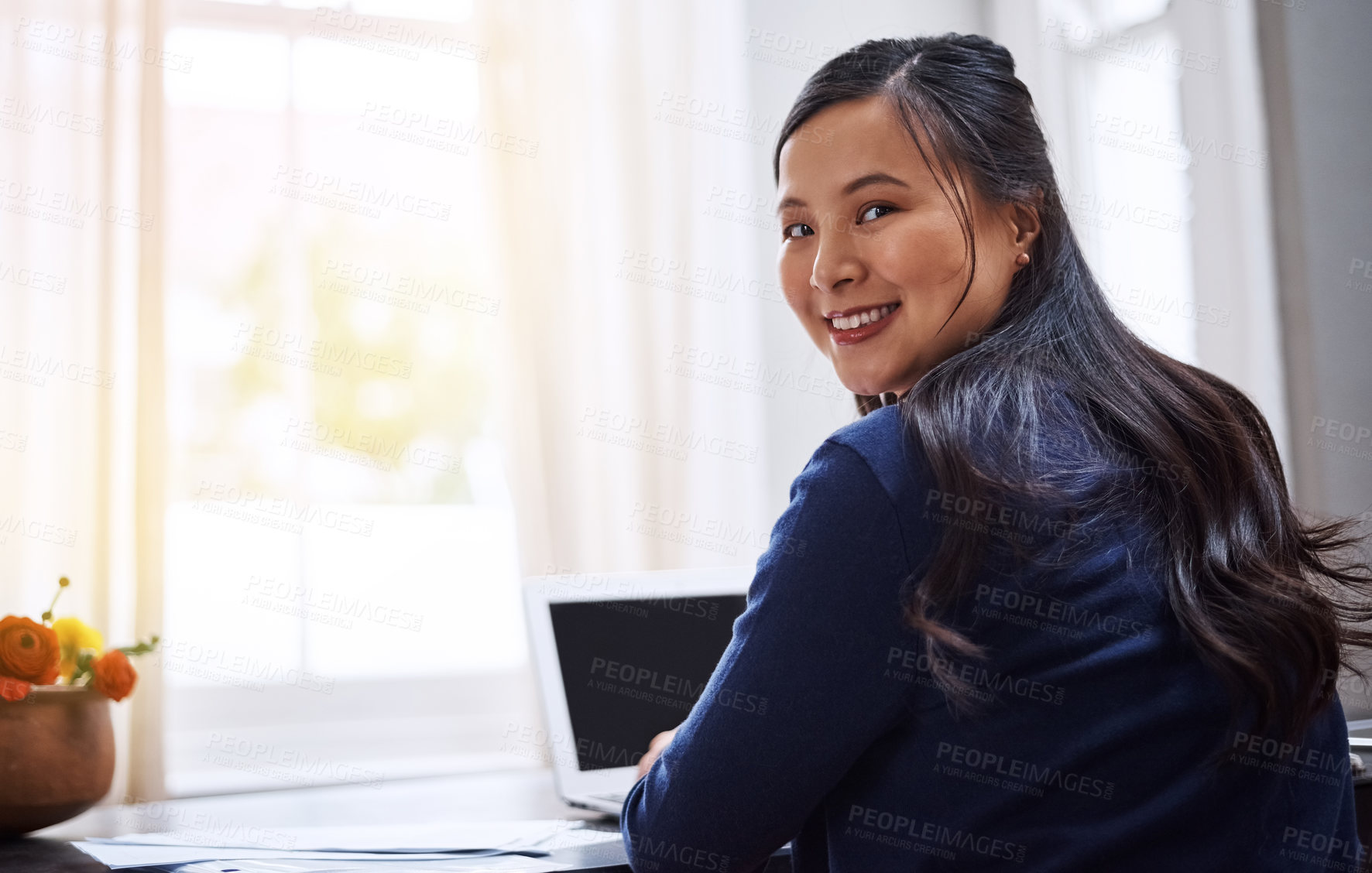 Buy stock photo Rearview portrait of an attractive young female entrepreneur working on her laptop at home