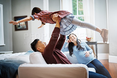 Buy stock photo Cropped shot of a handsome young man playing with his daughter on the sofa at home