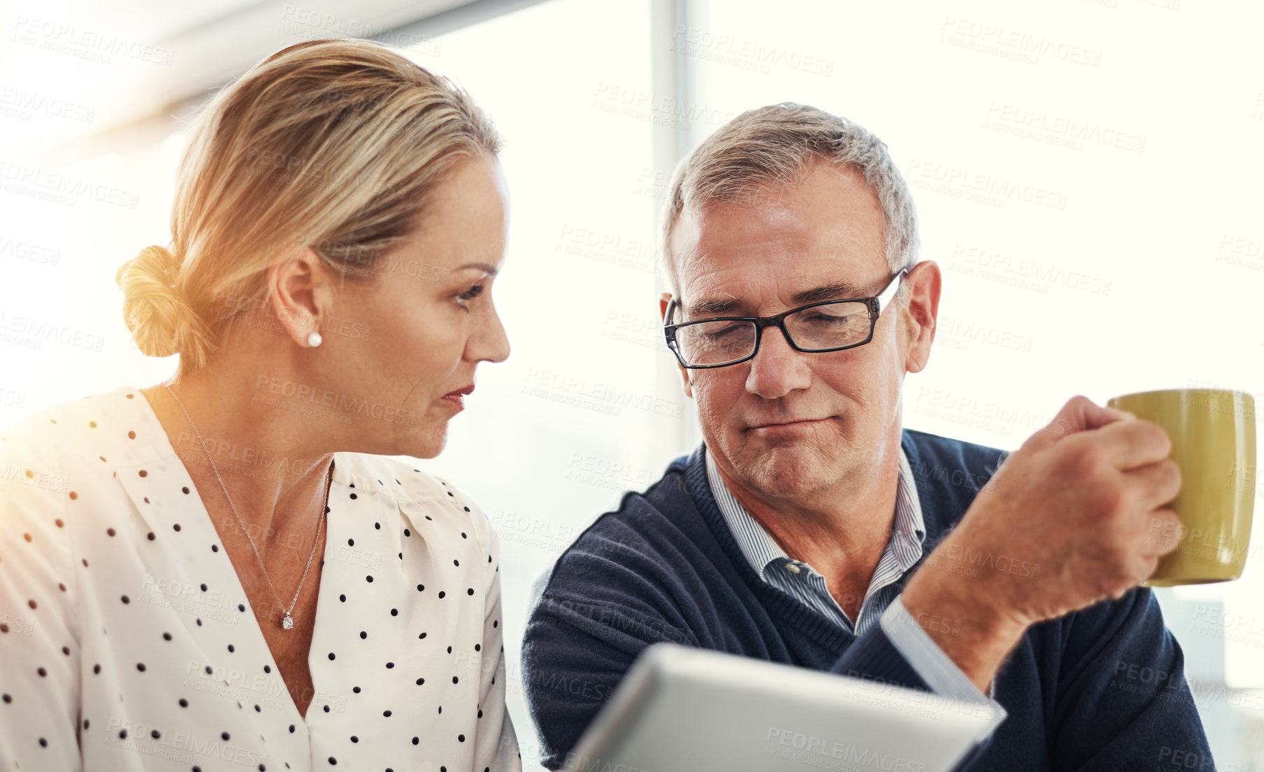 Buy stock photo Shot of a mature couple using a digital tablet together at home