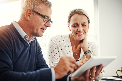 Buy stock photo Shot of a mature couple using a digital tablet together at home