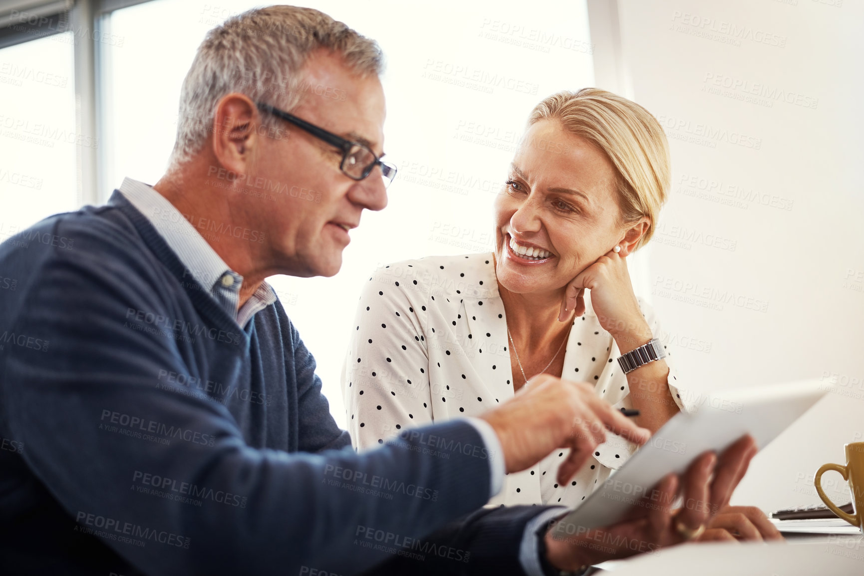 Buy stock photo Shot of a mature couple using a digital tablet together at home