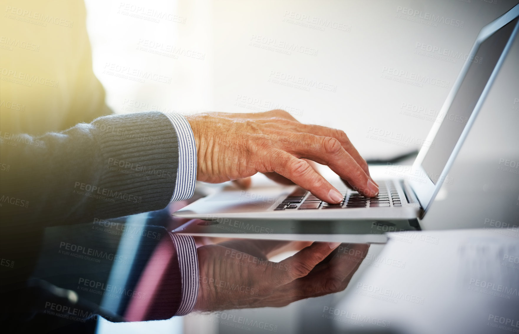 Buy stock photo Cropped shot of a businessman using a laptop at his work desk