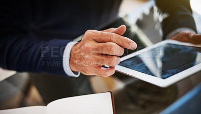 Buy stock photo Cropped shot of a businessman using a digital tablet at his work desk