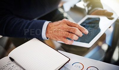 Buy stock photo Cropped shot of a businessman using a digital tablet at his work desk