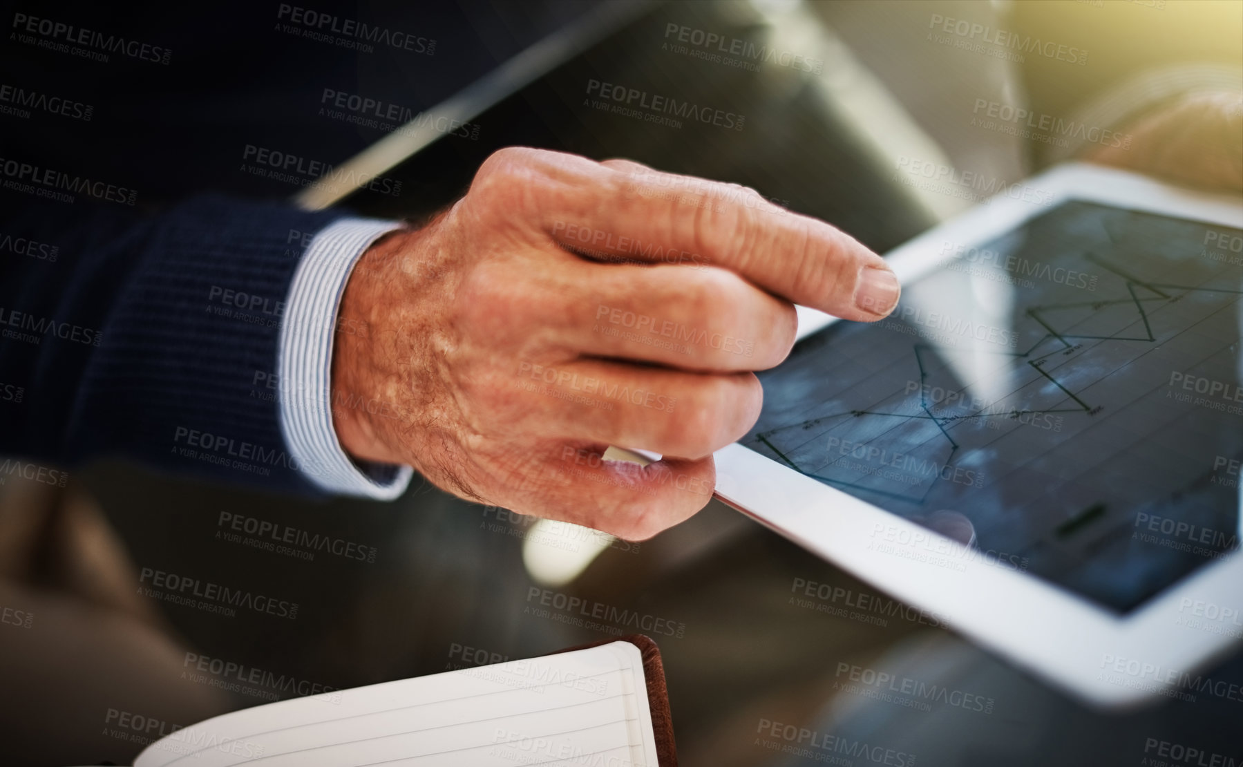 Buy stock photo Cropped shot of a businessman using a digital tablet at his work desk