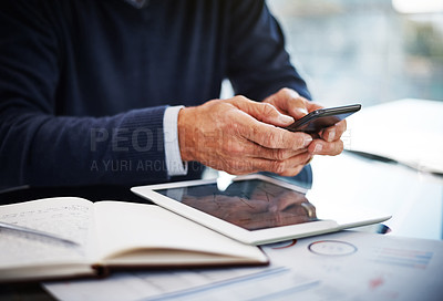Buy stock photo Cropped shot of a businessman using a mobile phone at his work desk