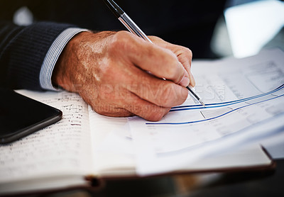 Buy stock photo Cropped shot of a businessman writing on a document at his work desk