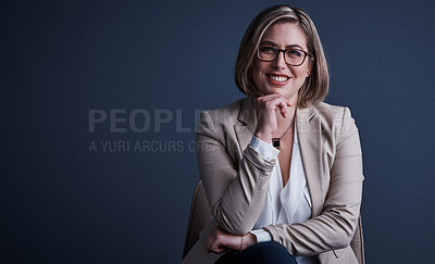 Buy stock photo Studio portrait of an attractive young corporate businesswoman posing against a dark background