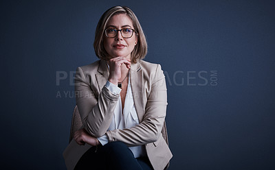 Buy stock photo Studio portrait of an attractive young corporate businesswoman posing against a dark background