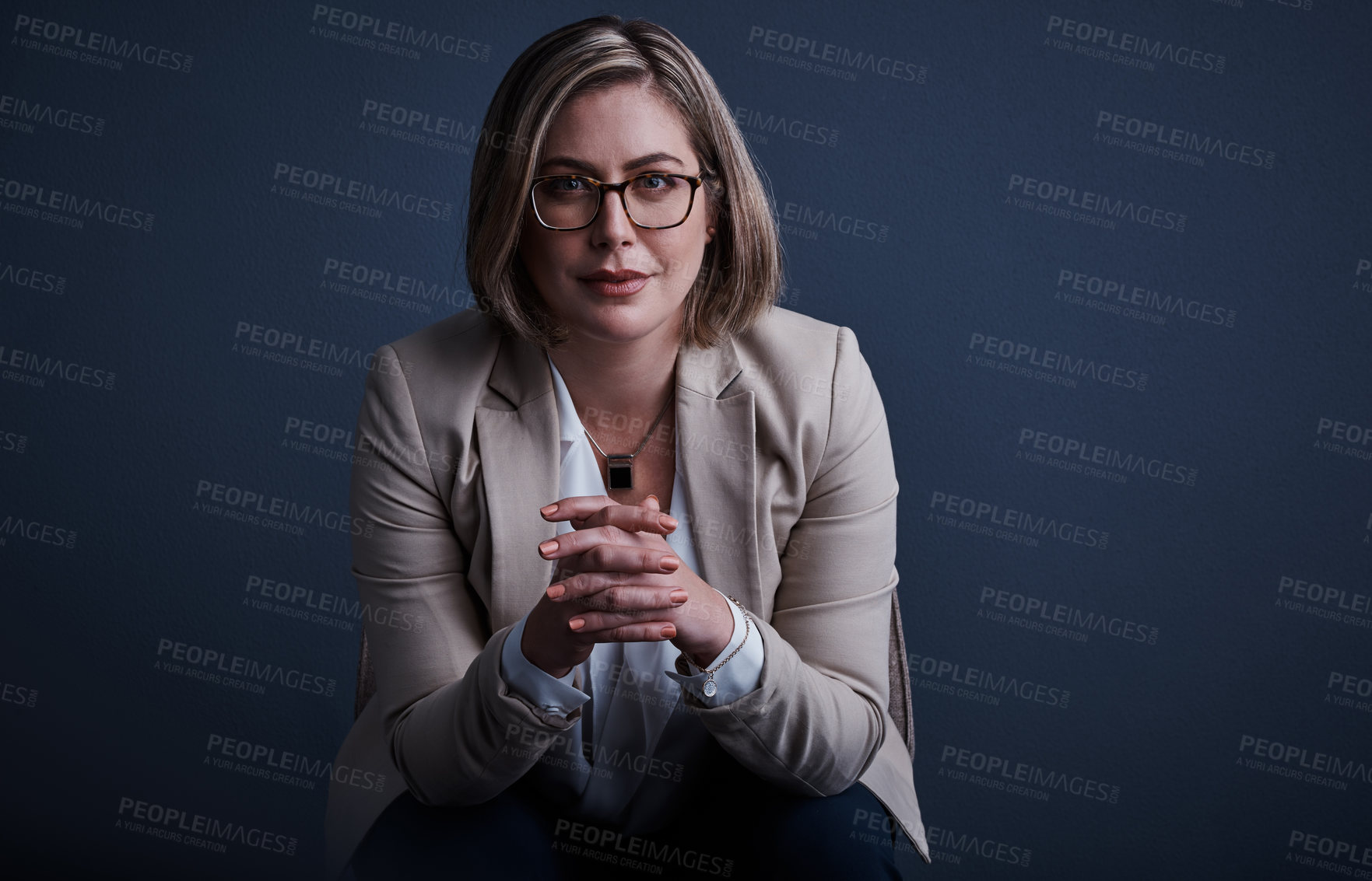 Buy stock photo Studio portrait of an attractive young corporate businesswoman posing against a dark background