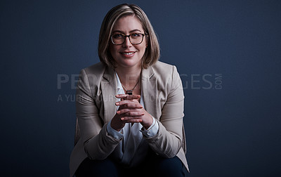 Buy stock photo Studio portrait of an attractive young corporate businesswoman posing against a dark background