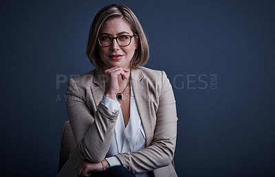 Buy stock photo Studio portrait of an attractive young corporate businesswoman posing against a dark background