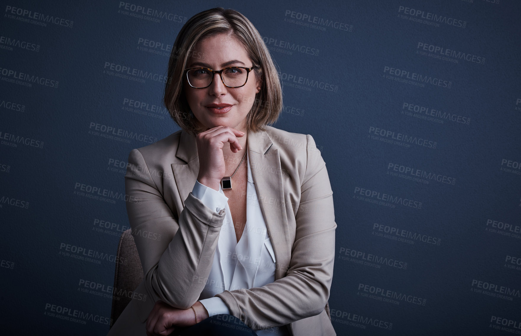 Buy stock photo Studio portrait of an attractive young corporate businesswoman posing against a dark background