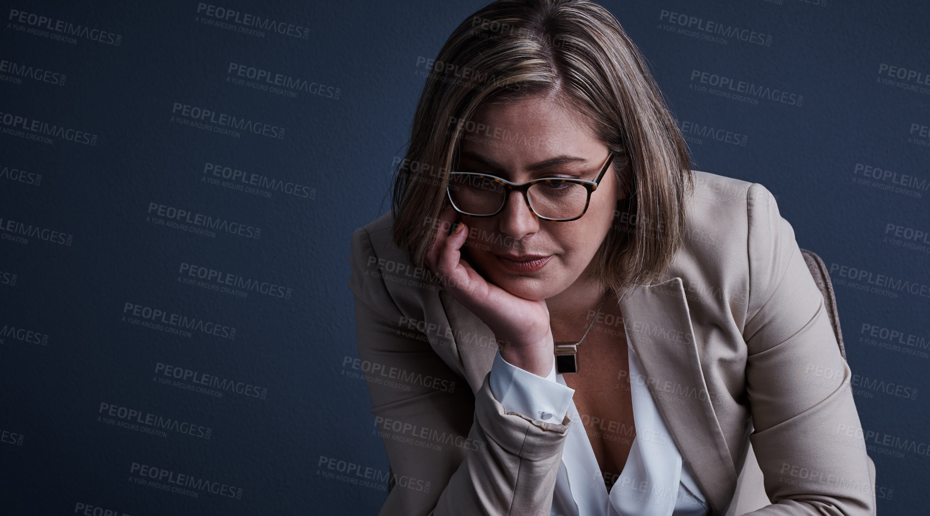 Buy stock photo Studio shot of a young corporate businesswoman looking stressed against a dark background