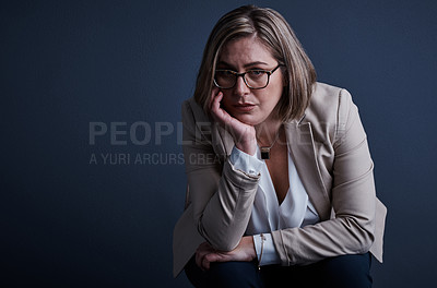 Buy stock photo Studio portrait of a young corporate businesswoman looking stressed against a dark background