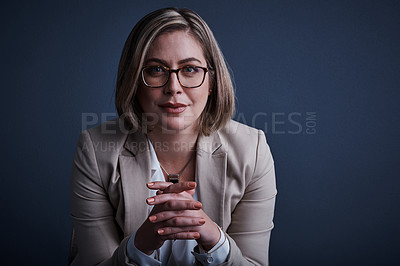 Buy stock photo Studio portrait of an attractive young corporate businesswoman posing against a dark background