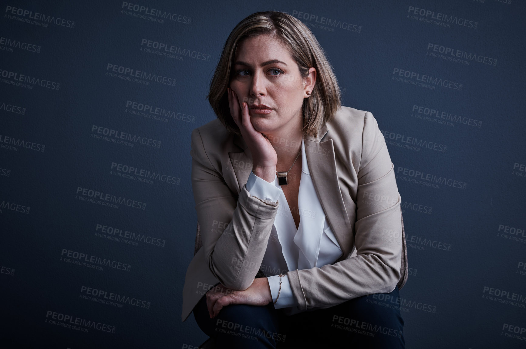 Buy stock photo Studio portrait of a young corporate businesswoman looking stressed against a dark background