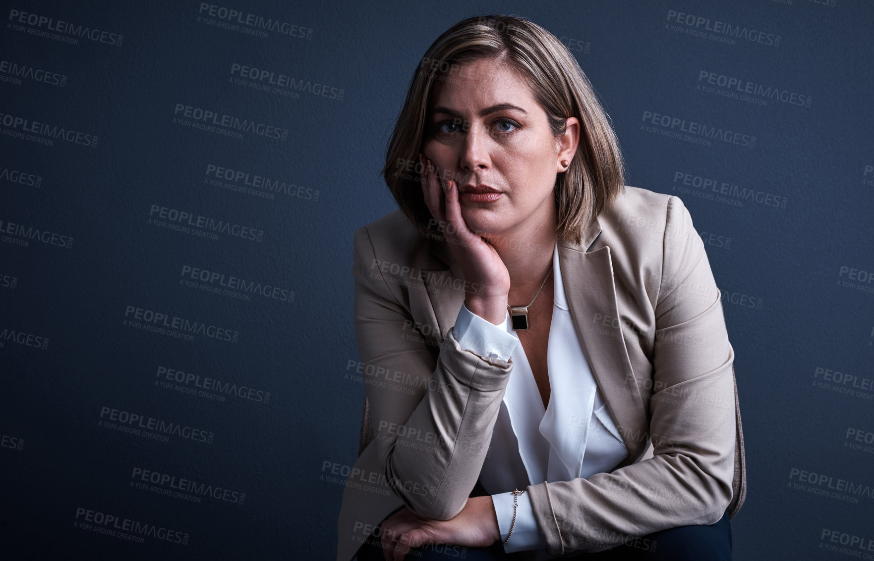 Buy stock photo Studio portrait of a young corporate businesswoman looking stressed against a dark background