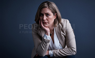 Buy stock photo Studio portrait of a young corporate businesswoman looking stressed against a dark background