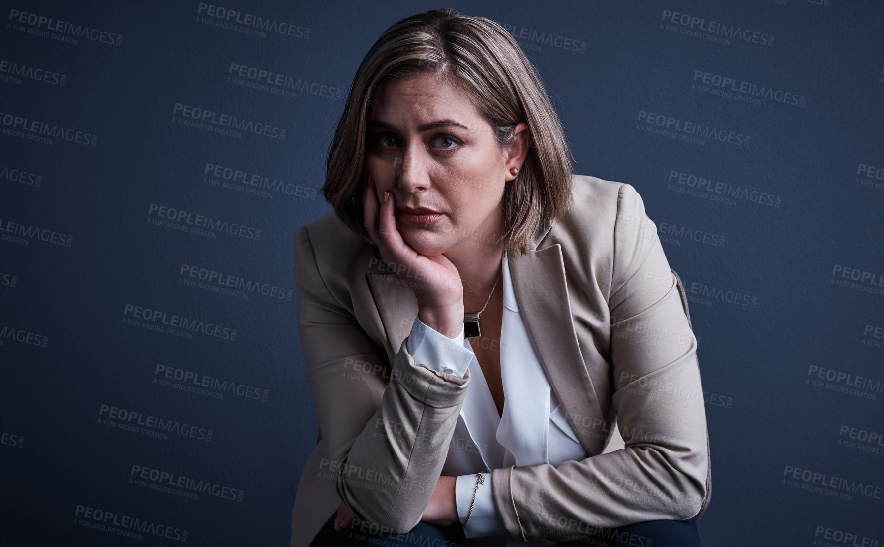 Buy stock photo Studio portrait of a young corporate businesswoman looking stressed against a dark background