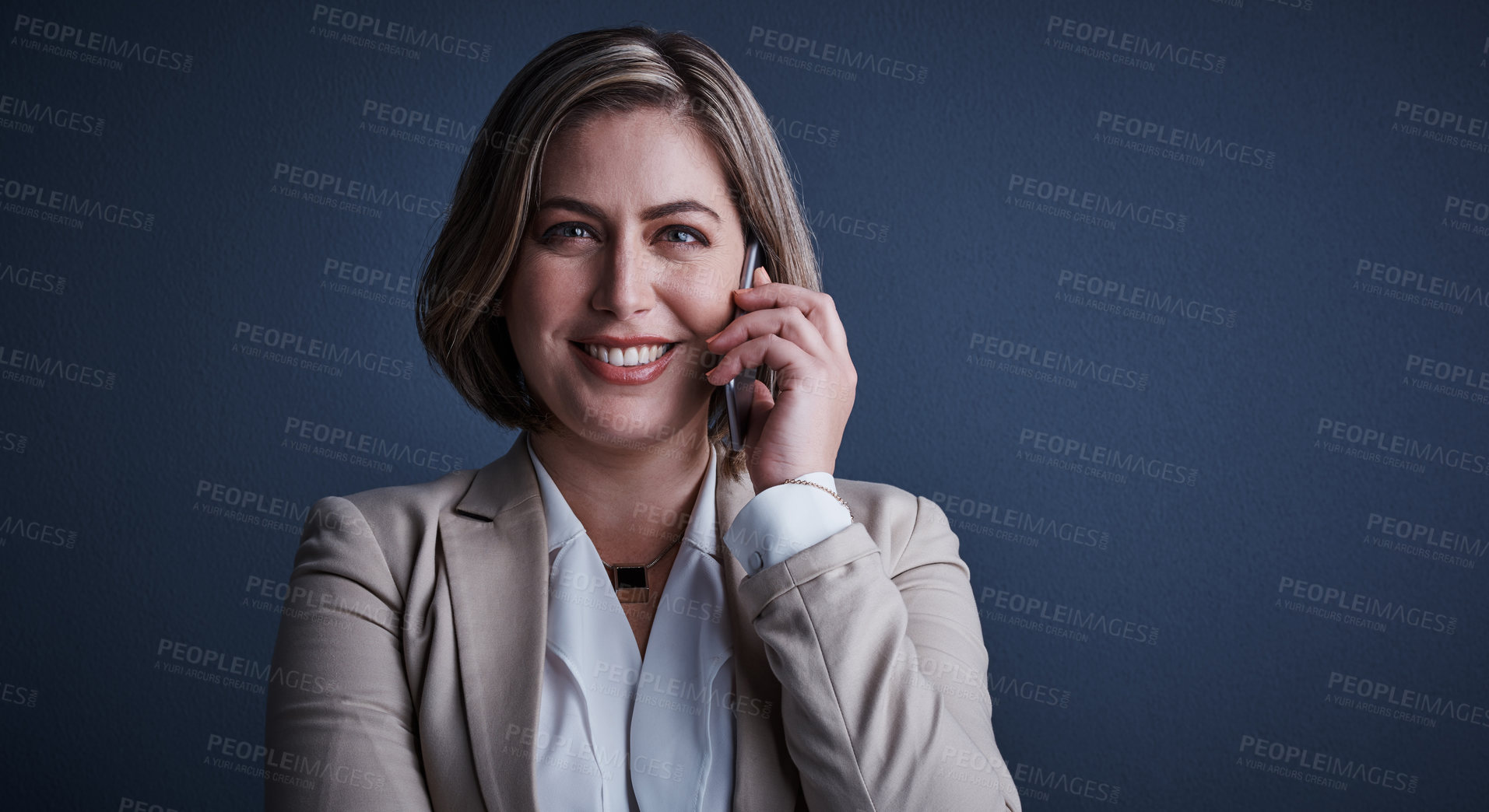 Buy stock photo Studio portrait of an attractive young corporate businesswoman making a call against a dark background