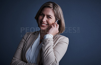 Buy stock photo Studio portrait of an attractive young corporate businesswoman making a call against a dark background