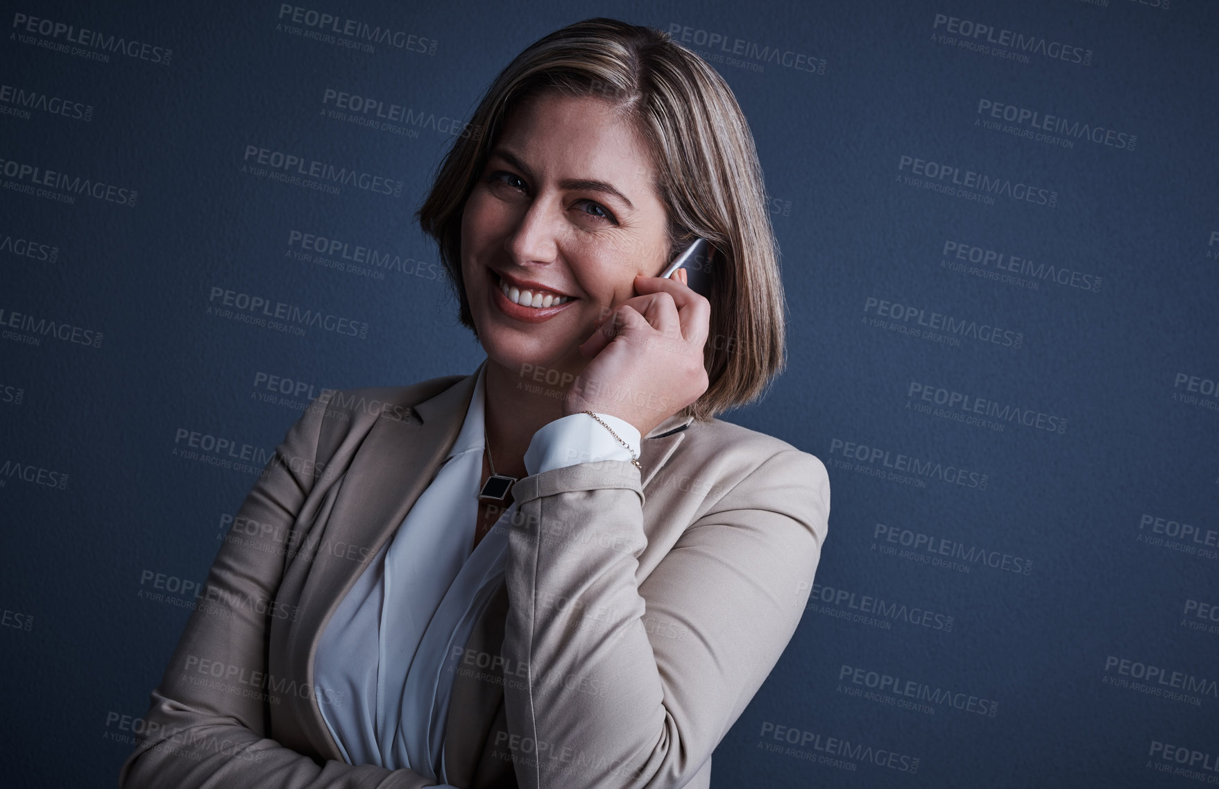 Buy stock photo Studio portrait of an attractive young corporate businesswoman making a call against a dark background