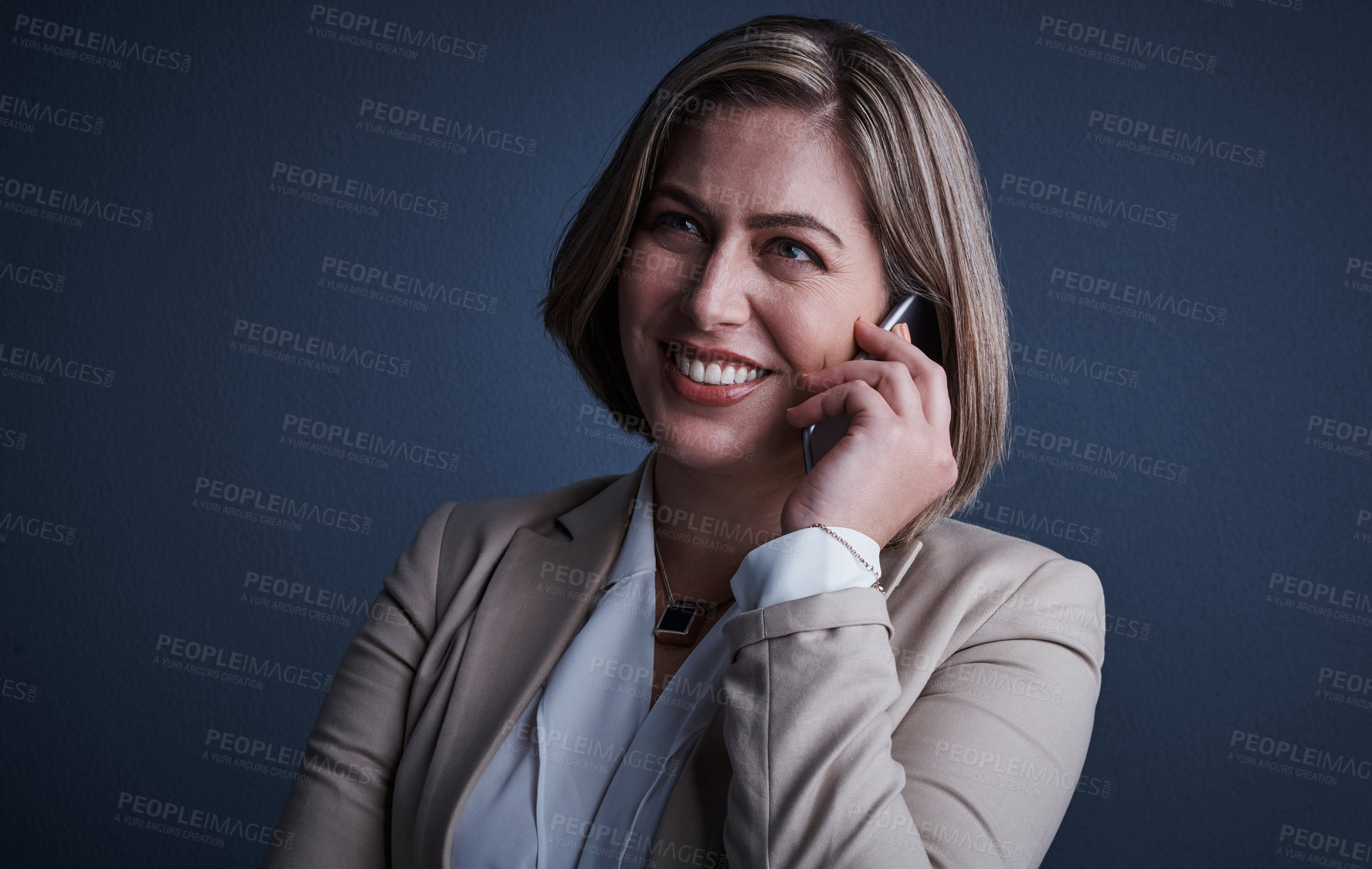 Buy stock photo Studio shot of an attractive young corporate businesswoman making a call against a dark background