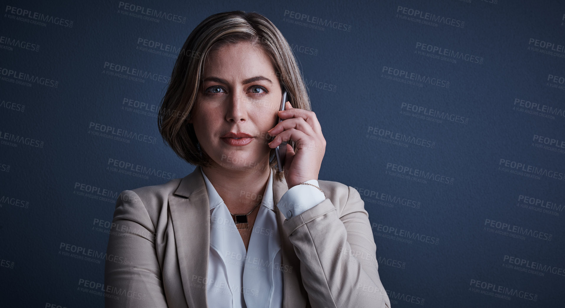 Buy stock photo Studio portrait of an attractive young corporate businesswoman making a call against a dark background