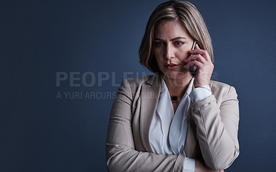 Buy stock photo Studio shot of an attractive young corporate businesswoman making a call against a dark background