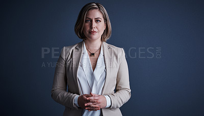 Buy stock photo Studio portrait of an attractive young corporate businesswoman posing against a dark background