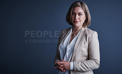 Buy stock photo Studio portrait of an attractive young corporate businesswoman posing against a dark background