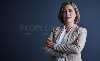 Buy stock photo Studio portrait of an attractive young corporate businesswoman posing with her arms crossed against a dark background