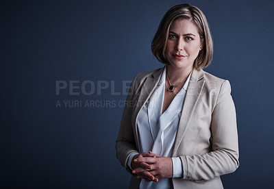 Buy stock photo Studio portrait of an attractive young corporate businesswoman posing against a dark background