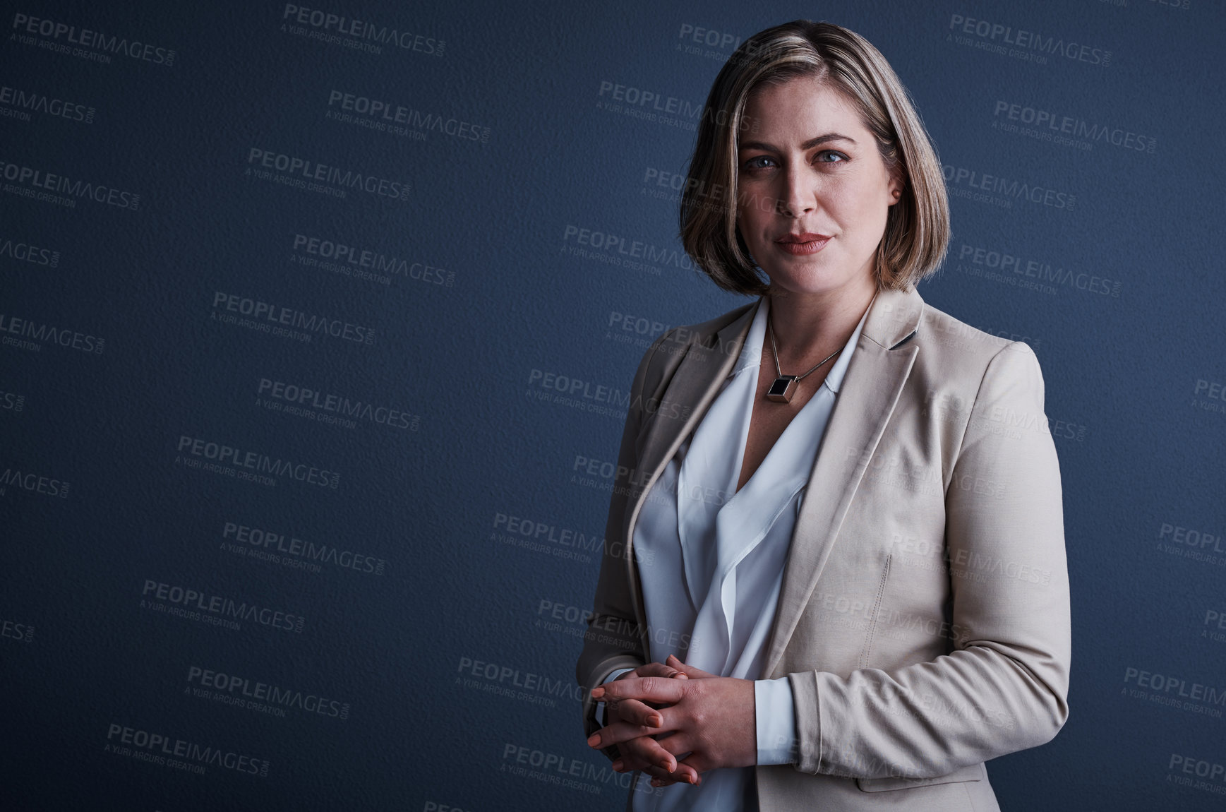 Buy stock photo Studio portrait of an attractive young corporate businesswoman posing against a dark background