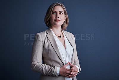 Buy stock photo Studio shot of an attractive young corporate businesswoman posing against a dark background