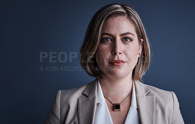 Buy stock photo Studio portrait of an attractive young corporate businesswoman posing against a dark background