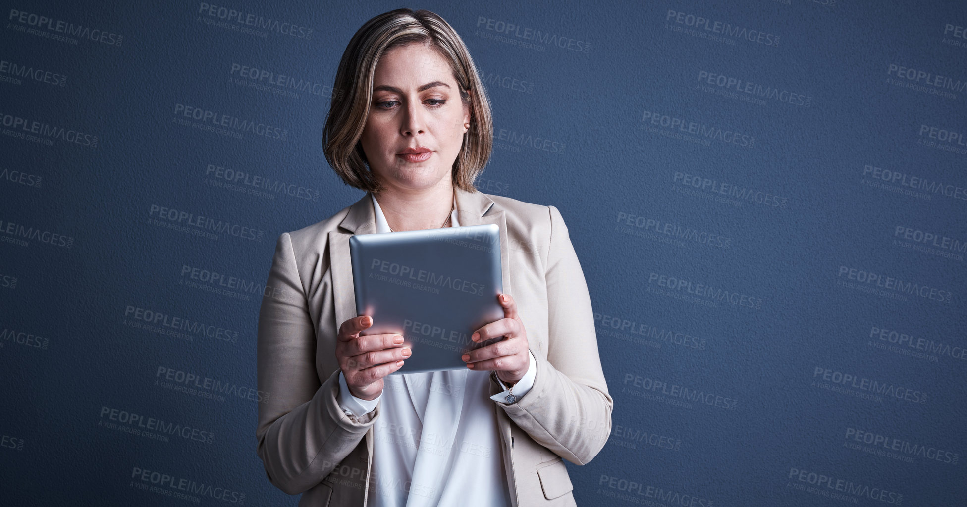 Buy stock photo Studio shot of an attractive young corporate businesswoman using a tablet against a dark background