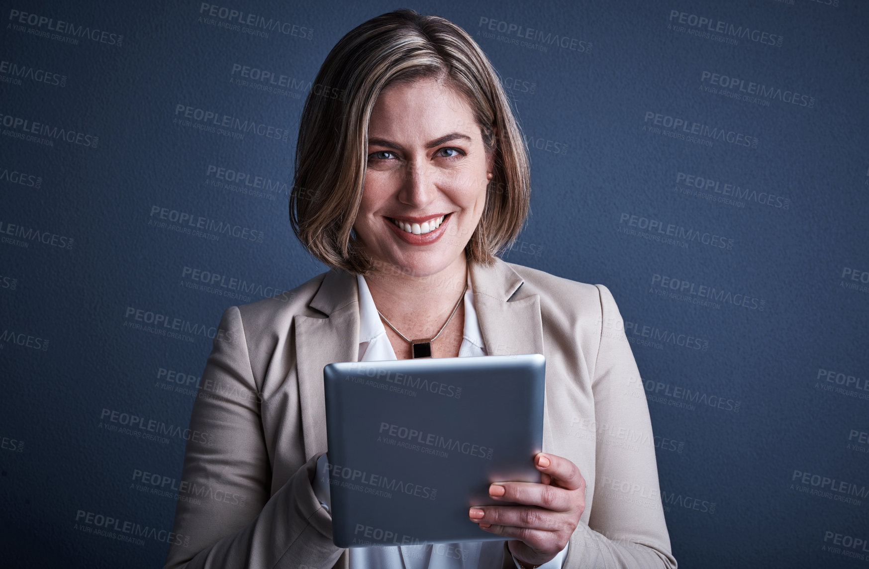 Buy stock photo Studio portrait of an attractive young corporate businesswoman using a tablet against a dark background