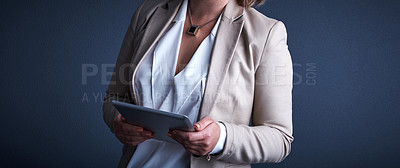 Buy stock photo Studio shot of an unrecognizable corporate businesswoman using a tablet against a dark background